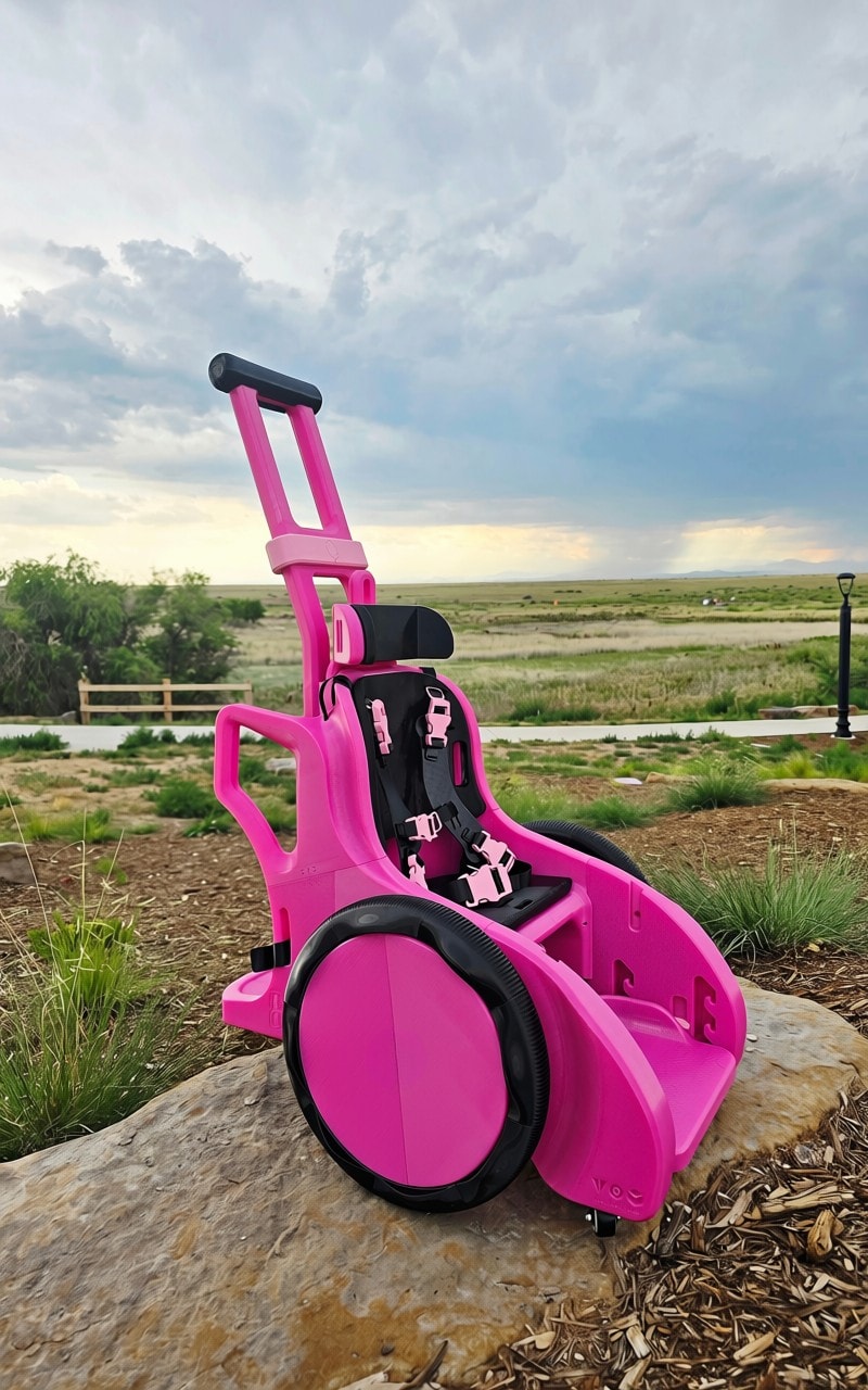 Pink Minnie Mouse children's mobility wheelchair outdoors