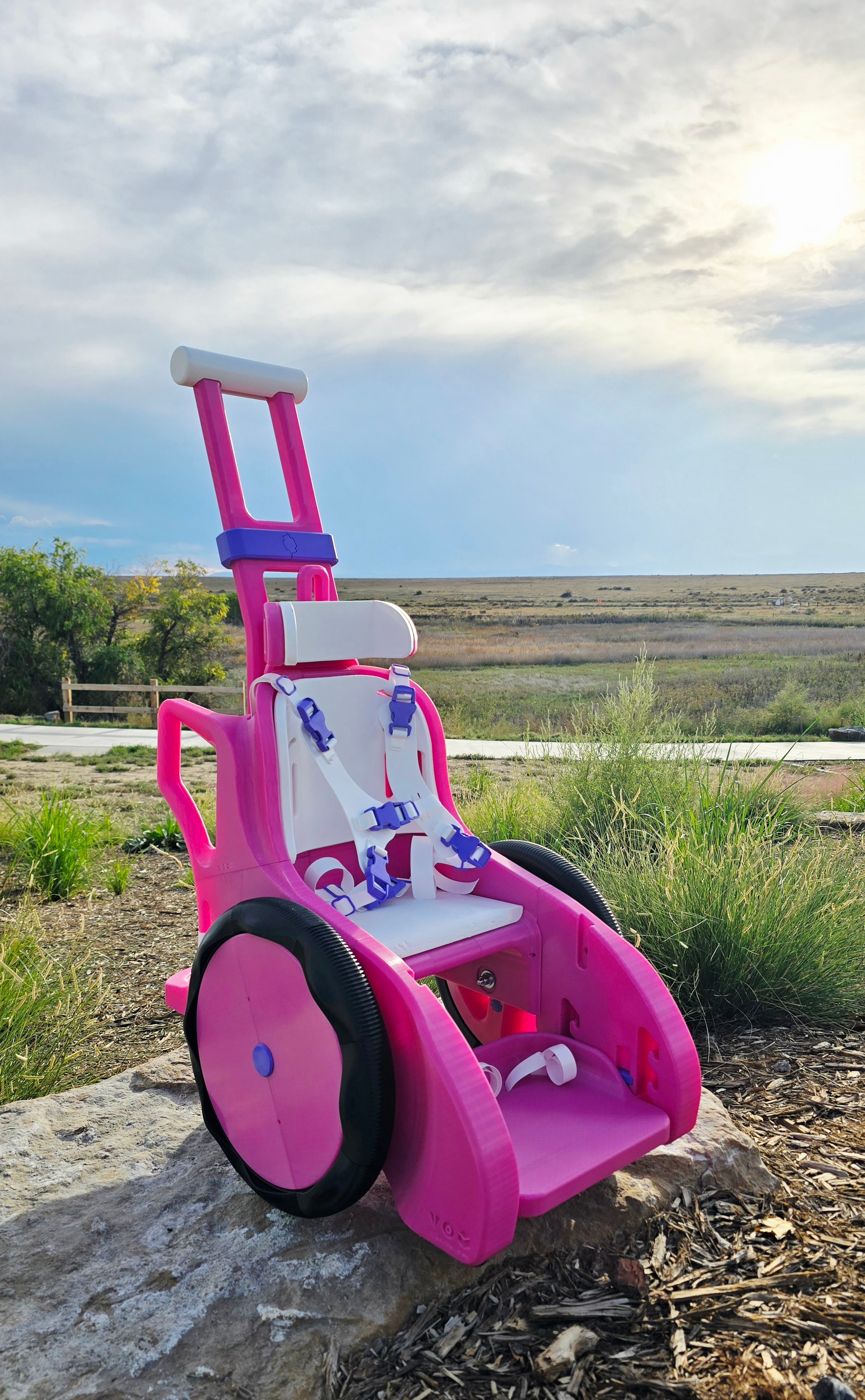 Custom pink 3D-printed wheelchair built for Scottie, 1 year old — front view