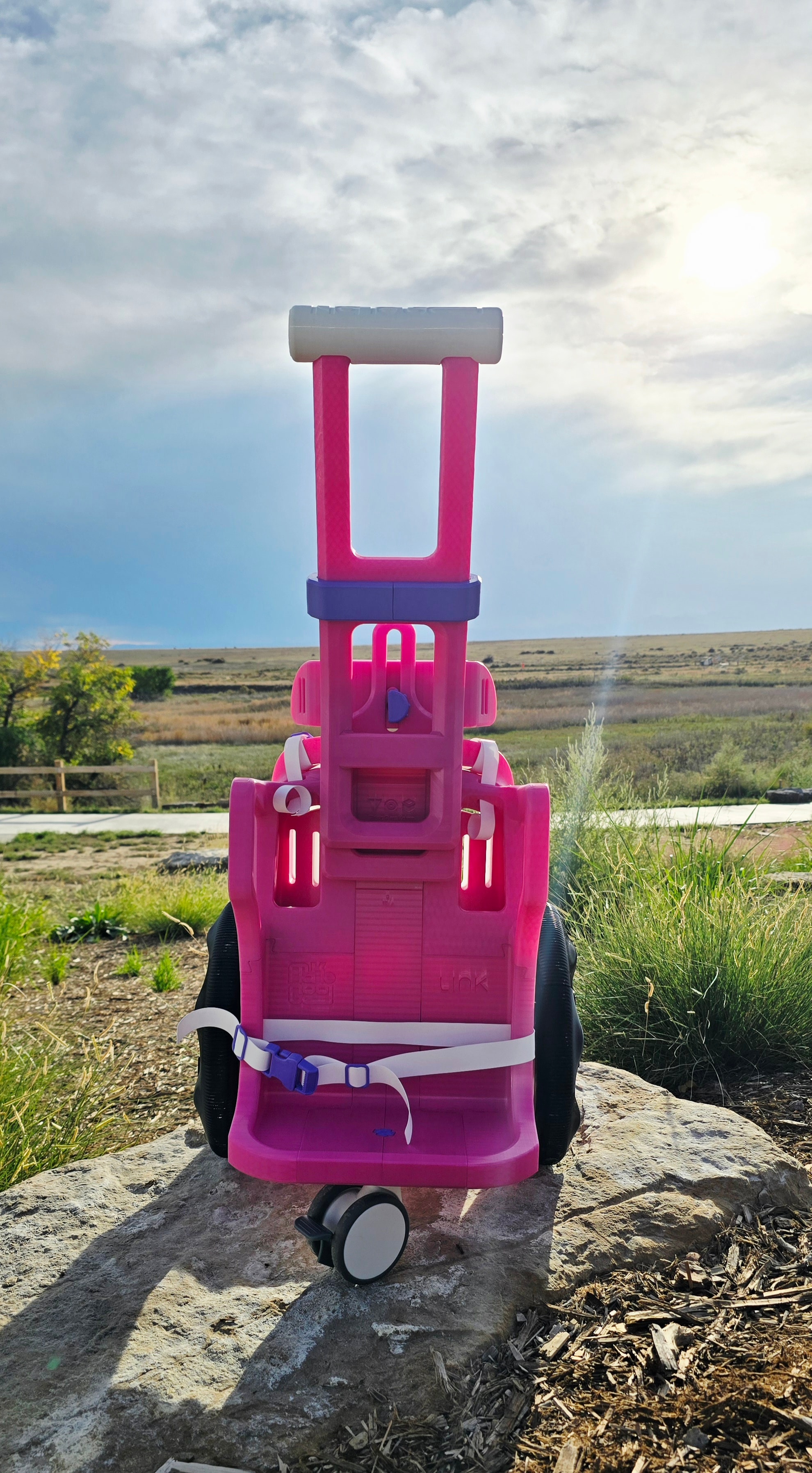 Custom pink 3D-printed wheelchair built for Scottie, 1 year old — rear view